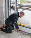 Builder using Extendable 36 Inch Level With Locking Design And Continuous Marking Edge Type 80T for precise door framing.
