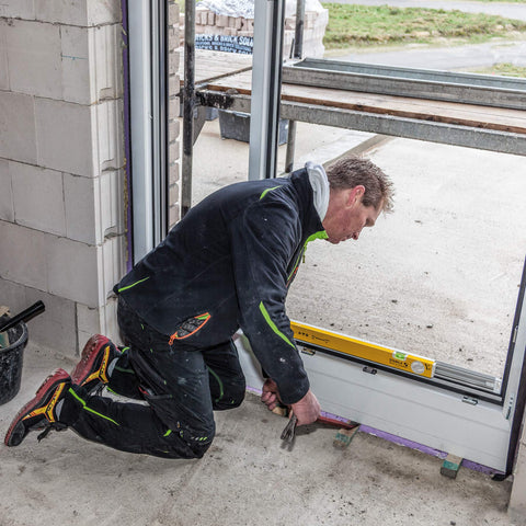 Builder using Extendable 36 Inch Level With Locking Design And Continuous Marking Edge Type 80T for precise door framing.