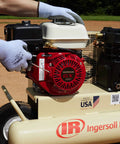 User adjusting the Honda engine on the 135 Psi 5.5 Hp Gas Powered Air Compressor for optimal performance.