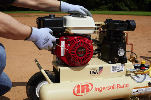 User adjusting the Honda engine on the 135 Psi 5.5 Hp Gas Powered Air Compressor for optimal performance.
