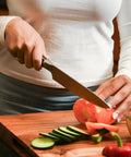 Person slicing vegetables on wood board using Wood Cutting Board Wax 8 Oz Food Grade Mineral Oil And Beeswax Conditioner For Butcher Block