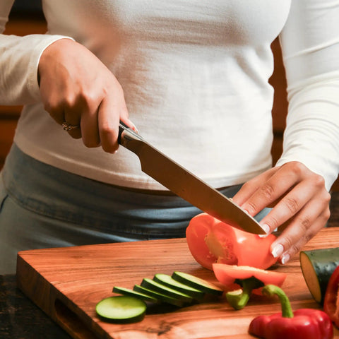 Close-up of slicing vegetables on wooden cutting board with knife, ideal for Wood Butter 4 Fl Oz Cutting Board Wax Conditioner For Butcher Block And Wooden Kitchen Tools All Natural Food Grade Mineral Oil And Beeswax Protects Wood From Drying Cracking And Warping While Keeping Surfaces No Mess And Ready To Use.