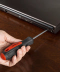 Person using Everyday 18 Piece Screwdriver Set With Wall Mount And Magnetic Tips for laptop repair, non-slip handle visible