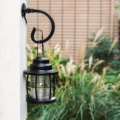 Outdoor black metal lantern on hook mount with greenery, part of 4 Pack Metal Landscape Lighting Mounting Brackets With 3/4-14NPSM Threads For Tree Deck And Wall Mounts