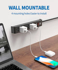 Rock Solid Six Outlet Surge Protector Power Strip With Six Foot Extension Cord And Six Hundred Joule Defense For Bulletproof Home Office Gaming Workstation Setup mounted on wall.