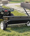 Tow Behind Lawn Spreader With Aeration Spikes For A Beefy Lawn Boost 32 Inch Wide Broadcast Spreader With 72 Aeration Tines hitched to ATV
