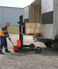 Heavy Duty Electric Pallet Stacker And Badass Off Road Workhorse That Flexes Hard Material Moves On Any Job Site And Cruises Over Uneven Ground Like A Real Champ lifting crates from a truck.