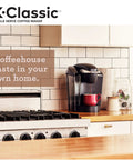 K Classic Single Serve Coffee Maker For K Cup Pods Black Finish With Removable Drip Tray on kitchen counter next to stove