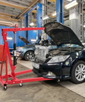 Heavy Duty Hydraulic Engine Hoist With Telescopic Boom And 6 Roll Smooth Casters, 4400 Lb in a garage lifting an engine.