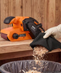 Workhorse Grade 3 By 21 Belt Sander With 7 Amp Motor And Six Variable Speeds delivering sawdust into a waste bin.