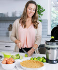 Compact Automatic Citrus Juicer With Hands Free Electric Press For Fresh Orange Lemon Lime Extract on kitchen counter with limes.