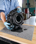 Mechanic using Premium Oil Absorbent Mat Pads 15 x 20 Inches, Heavy Duty 28 Oz Absorbency, for spill cleanup in workshop