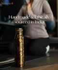 Copper Water Bottle 1 Liter With Ayurvedic Health Benefits beside person practicing yoga in gym