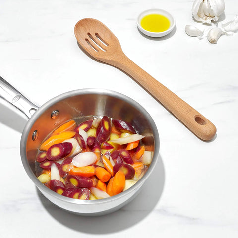 Wooden slotted spoon next to pan of vegetables, part of Three Piece Wooden Utensil Set With Solid Beachwood Spoon Slotted Spoon And Turner For Everyday Cooking No Fuss Kitchen Tools Built To Stir Lift And Serve Like A Pro