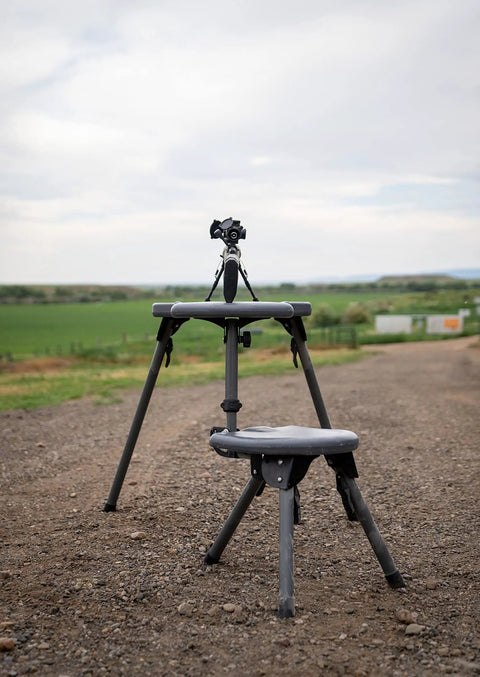Stable Table Lite With Weatherproof Tabletop And Ambidextrous Seat fully set up on a gravel path with rifle bipod support