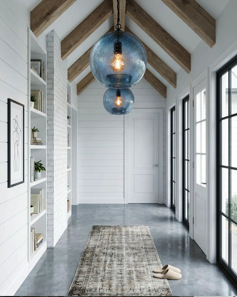CASAMOTION Modern Farmhouse Blue Glass Globe Pendant Light 11" Dia. hanging in a well-lit hallway with rustic decor.