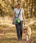 10L Dog Food Travel Bag With Collapsible Bowls For On-The-Go Kibble, woman walking dog in forest holding bag with shoulder strap
