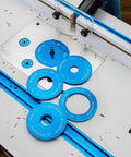 Locking Router Plate Insert Kit With Twist Locks For Router Table Insert Plate Aluminum Construction Fits Properly And Controls Dust No Tools Needed To Install 5 Pack Ideal For Woodworking And Dust Free Routing displayed on a router table with blue rings.