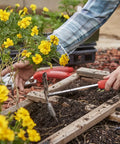Gardener using Premium Stainless Steel ComfortGEL All In One Hoe Cultivator With Comfy Grip For Weeding, Soil Aeration, And Bed Prep, Rust Resistant Garden Tool In Red on plants