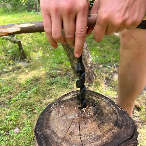Person using Heavy Duty Hand Auger Wood Drill With Scotch Eye Design for bushcraft, creating hole in tree stump