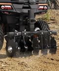 28-Inch Heavy-Duty Disc Plow Harrow With Universal 2-Inch Receiver attached to ATV, black steel, used for soil preparation.