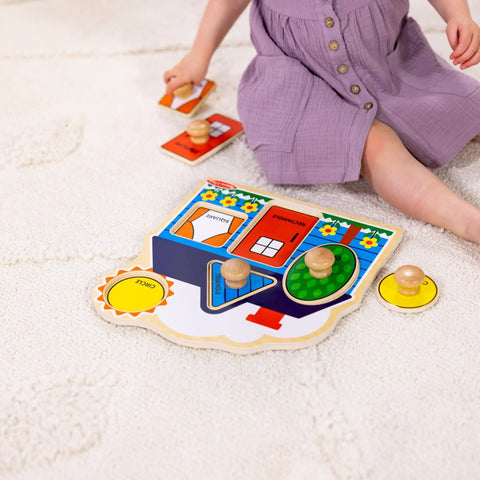 Child playing with First Shapes Jumbo Knob Puzzle For Toddlers With Wooden Peg Pieces on a soft carpet, enhancing fine motor skills.