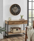 Killer Twenty Four Inch Oversized Wall Clock Featuring Real Moving Gears Heavily Distressed Antique Gold Dial Bold Roman Numerals above wooden table.