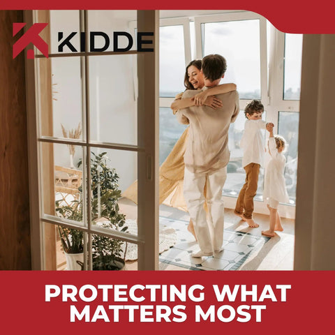 A family embracing near a large window with Kidde logo and slogan 'Protecting What Matters Most' in a bright living room.