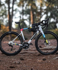 Slim Fit Bike Top Tube Bag Waterproof IPX4 Magnetic Closure Frame Pouch on road bike with dual mounting options in a forest setting