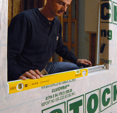 Worker using Extendable 36 Inch Level With Locking Design And Continuous Marking Edge Type 80T for framing a window opening