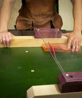 Person using ZeroPlay Miter Bars 2-Pack with MatchFit Jig Handle on green table saw sled for precise cuts.