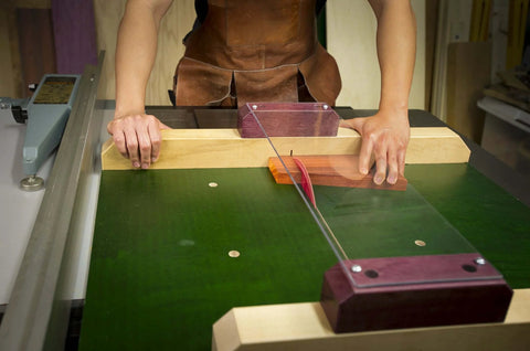 Person using ZeroPlay Miter Bars 2-Pack with MatchFit Jig Handle on green table saw sled for precise cuts.