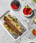 Whole fish on 50 Pack Half Size Aluminum Pans Disposable Cookie Sheets with lemon slices, berries, and orange juice on side, 12.7 x 7.9 inches.