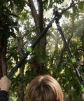 Person using extendable bypass lopper with 25-37 inch telescoping handles for one point five inch tree trimming in garden