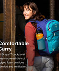 Woman carrying Daylite Expandable 26 Plus 6 Travel Pack Black Lightweight Durable Daypack With 6L Expansion For Flexible Capacity Ideal For Weekend Getaways And Extended Trips, blue color variant, outdoors.