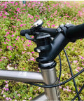Lightweight 31.8mm Bike Stem 90mm, 0 To 45 Degree Adjustable Riser attached to handlebar and steerer on bicycle, in floral setting.