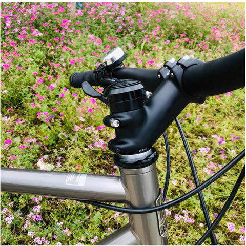 Lightweight 31.8mm Bike Stem 90mm, 0 To 45 Degree Adjustable Riser attached to handlebar and steerer on bicycle, in floral setting.
