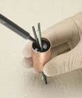 Applying 3M Scotch-Weld Clear Epoxy Adhesive DP100 Plus to wires in a copper fitting, showcasing reliable bonding application.
