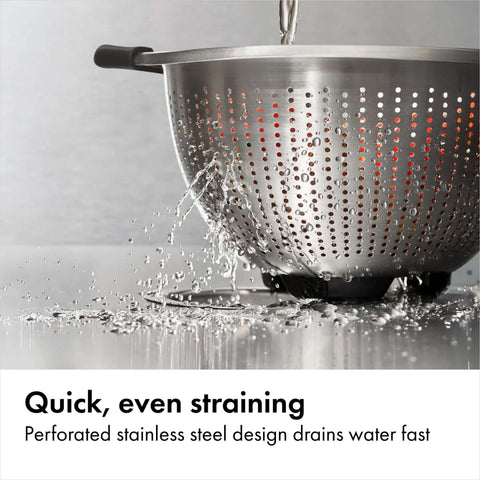 Non Slip Grip 5 Qt Stainless Steel Colander with Comfortable Handles for Pasta and Veggies straining water on counter