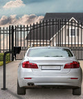 Beefy Universal Gate Keypad Mounting Post For Swing And Sliding Openers next to a closed metal gate and parked car