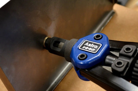 Close-up of 13-Inch Nut And Thread Hand Riveter Kit With Toolless Quick-Change Head in use on metal surface.