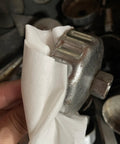 Close-up of Top Notch Heavy Duty Industrial Shop Towels Multipurpose Cleanroom Wipes used for cleaning a metal tool.