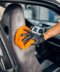 Black vinyl exam gloves, 4mil, latex-free, size medium; hand wiping car seat with orange microfiber cloth
