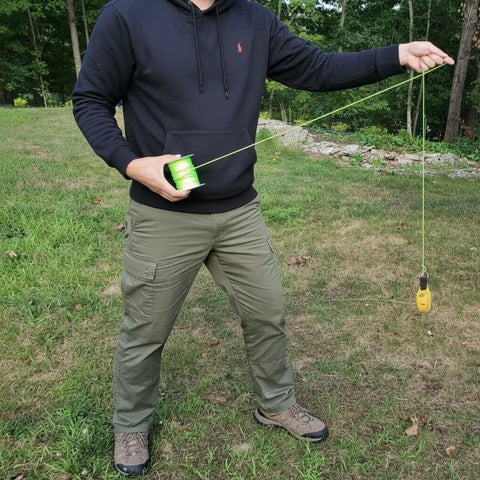 Man demonstrating use of Throw Weight Pouch Set For Arborist Tree Climbing, 2 Pack, 8 Oz And 12 Oz, Luminous Yellow.