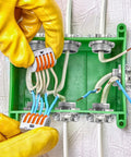 Person installing 50 Pack Half Inch Clamp Type Cable Connectors for NM Cable in green junction box, zinc alloy fittings visible