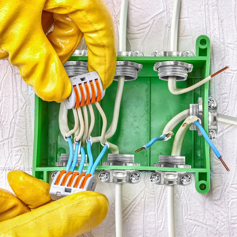 Person installing 50 Pack Half Inch Clamp Type Cable Connectors for NM Cable in green junction box, zinc alloy fittings visible