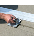 Using the Heavy Duty Zinc Concrete Groover With DuraSoft Handle 6 By 4 And Three Eighths Inch Blade on fresh concrete surface.