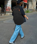 Person walking with the Road Ready Oxford Fabric Drum Storage Bag With Hella Tough Waterproof Seams on their back.