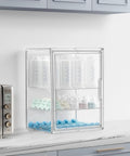 Three Tier Clear Acrylic Baby Bottle Storage Organizer on countertop holding bottles, pacifiers, and accessories with magnetic door.