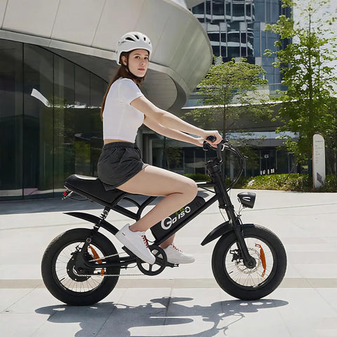 Person riding black 16 Inch Fat Tire Electric Bike For Adults And Teens With Peak 1500W Motor 28 MPH Top Speed 65 Mile Range 48V 15.6Ah Battery Full Suspension All Terrain Ebike For Mountains Snow And Sand Black in urban setting.